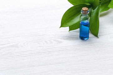 Blue essence healing tincture on white wooden table background with copy space. Herbal medicine concept. Alternative medicine.