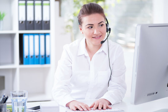Frau mit Headset sympathisch l&auml;chelnd im B&uuml;ro