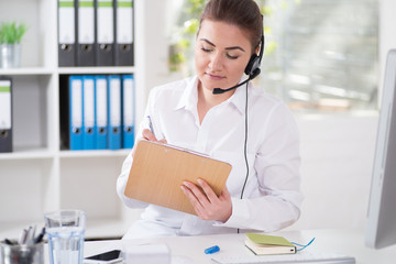 Frau mit Headset sympathisch lächelnd im Büro