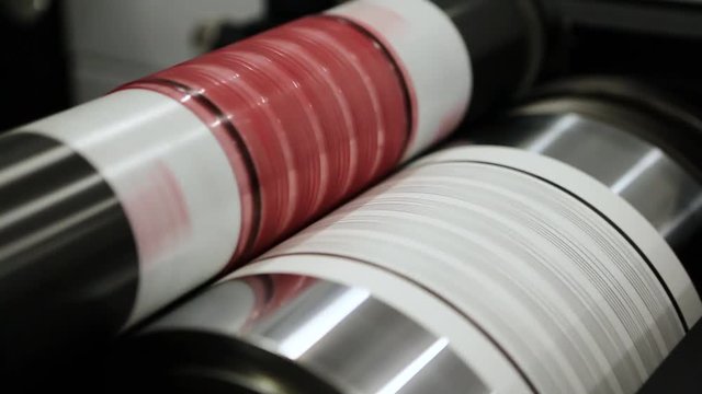 Flexography printing process on in-line press machine. Video of photopolymer plate stuck on printing cylinder, substrate is sandwiched between the plate and the impression cylinder to transfer the ink