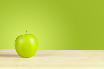 Green Apple on desk with Green background
