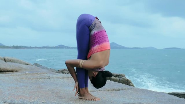 Woman training complex yoga exercises salutation to sun Surya Namaskar