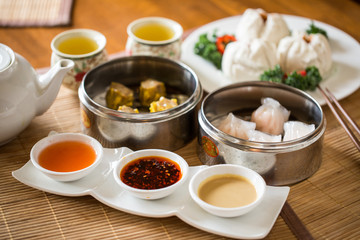 Chinese Dumpling Sampler Platter with Different Sauces and Hot Tea