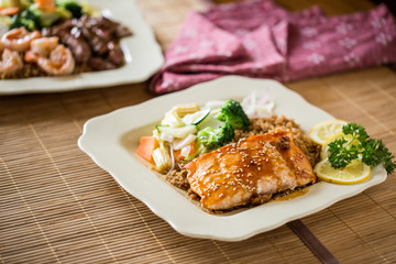 Asian Baked Salmon on a White Dinner Plate and Wood Table with Natural Window Light