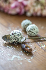 Close up of Sesame Coated Bliss Balls on Timber Board