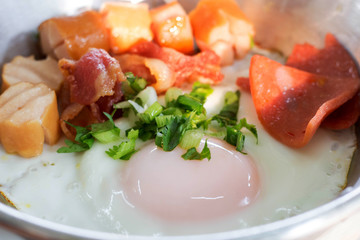 Pan-fried egg are made from fried egg, sausage, ham and bacon. Breakfast is served at the resort in Kanchanaburi, Thailand.