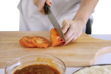 Unknown chef is cooking pizza in the kitchen