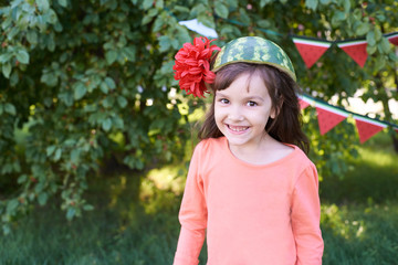 Small child. Pretty Girl. Watermelon on the head. Brightly colored flower