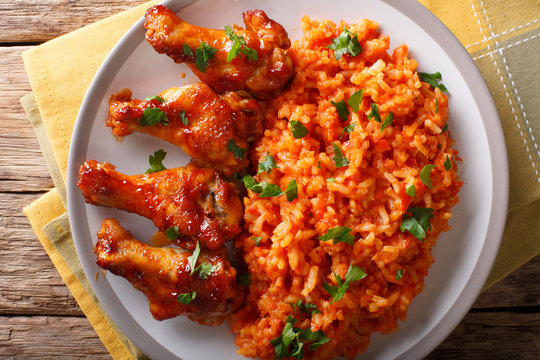 Classic Nigerian Jollof Rice with fried chicken wings close-up. horizontal top view