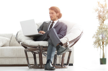 modern businessman with a laptop sitting in a stylish comfortabl