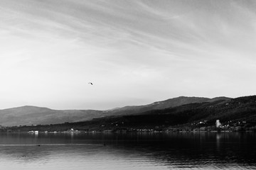 Beautiful view of Trasimeno lake (Umbria, Italy), with hills and sky reflecting on water