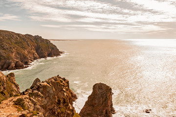 Beautiful seascape. A view of the Atlantic Ocean from the rock cape. Sintra. The rock mass. Lisbon. Portugal. February 2018: seeing the edge of the green top of the coastal rocks over the ocean.
