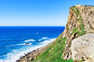  Beautiful seascape. A view of the Atlantic Ocean from the rock cape. Sintra. The rock mass. Lisbon. Portugal. February 2018: seeing the edge of the green top of the coastal rocks over the ocean.