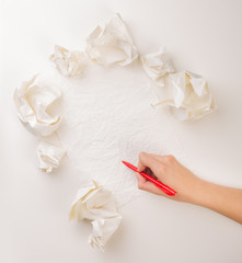 Writing hand in crumpled paper
