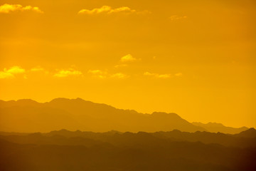 Golden sunset over the mountains. Silhouette of a mountain range against the sky at sunset