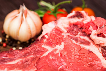 Raw beef steak with pepper, herbs and tomatoes