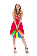 Laughing Woman In Red Dress Is Holding Colorful Shopping Bags
