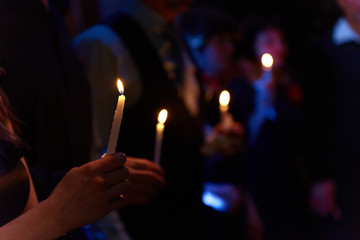 People hold candles light at dark scene