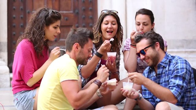 Tourists or friends eating ice cream slush and having fun