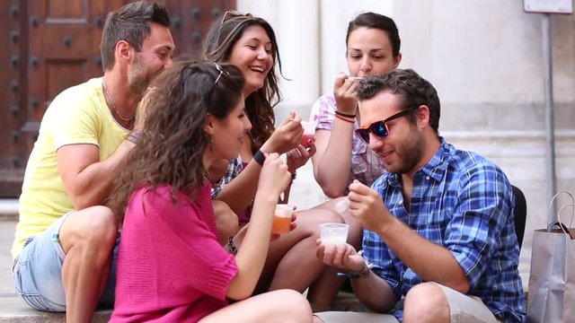 Tourists or friends eating ice cream slush and having fun