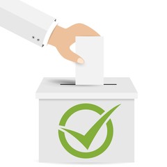 Hand putting a voting ballot in a slot of box