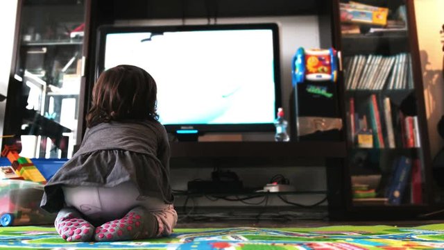 newborn baby watch tv on the carpet in livingroom socks back view
