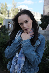 Pretty woman in jeans jacket posing in a city street