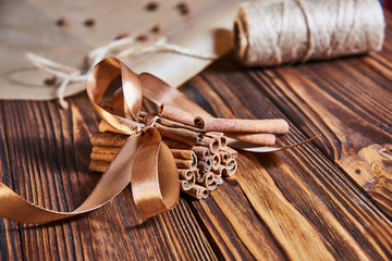 cinnamon sticks tied with ribbon on a brown wooden background
