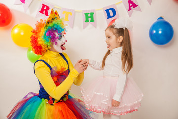 clown girl on the birthday of a child. A party for a child. shy Baby