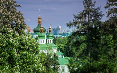 Fototapeta na wymiar Botanical garden with blooming lilac, spring landscape, St. George Cathedral of the Vydubychi Monastery, view on Dnipro river, Kyiv, Ukraine