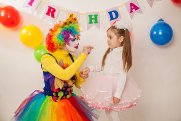 clown girl on the birthday of a child. A party for a child. shy Baby