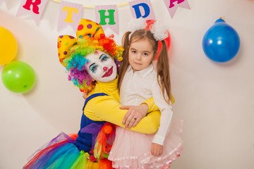 clown girl on the birthday of a child. A party for a child. shy Baby