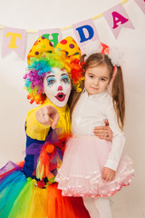 clown girl on the birthday of a child. A party for a child. shy Baby