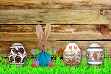 Happy Easter. Colorful easter eggs and rabbit on green grass.