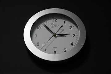 Wall clock, dial with arrows, soon three hours. Oval 