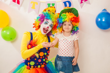 clown girl on the birthday of a child. A party for a child. A child in a clown wig