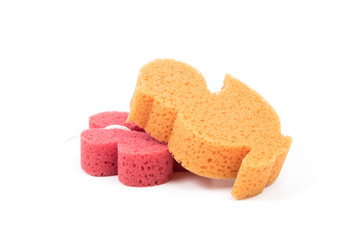 Flower and duck shaped bath sponge isolated on white background, surface. Red and orange bathing sponge.