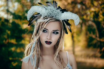 Beautiful model is posing in a forest with white horns 