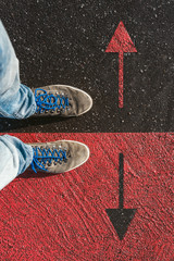 Concept of facing a crucial decision about which direction to go shown by shoes on different colored pathways - 197733572