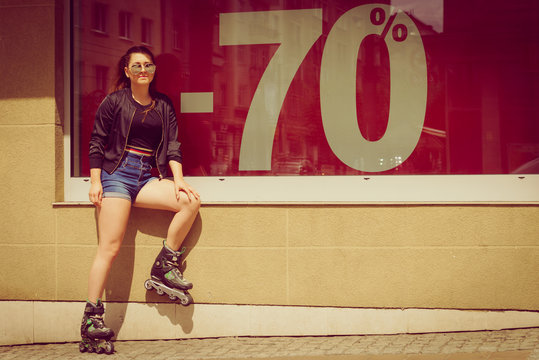 Woman wearing roller skates next to sale