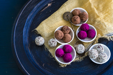 Flat lay of Bliss Balls and vintage brass spoons on Blue Distressed Timber Tray