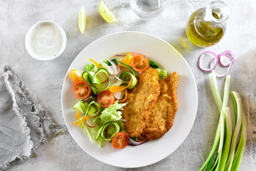 Vegetable salad and breaded chicken breast