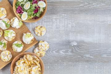 Delicious, nutritious cereal breads with cream cheese on kitchen table among some kitchen items.
