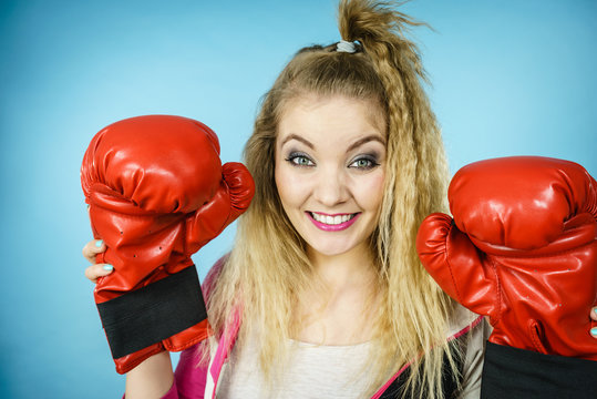 Funny girl in red gloves playing sports boxing