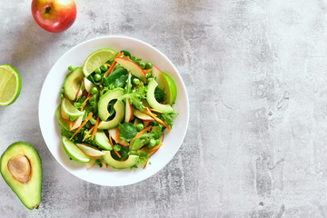 Vegetable salad with avocado, green pea, greens, apple