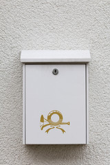 weißer Postkasten an einer weißen Wand