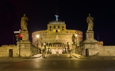 Fototapeta na wymiar Ponte Sant'Angelo bridge crossing the river Tiber and Castel Sant'Angelo, illuminated at night