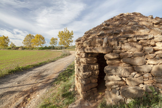 Landscape with construction for agricultural use. Stonecraft, Barraca de vinya, or caseta de pedra seca. Typical mediterranean rural structure. Sant Fruitos del Bages,Catalonia,Spain.