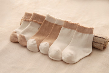 Baby socks hanging on the clothesline on wooden background