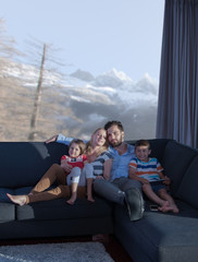 Naklejka premium happy young couple spending time with kids at home